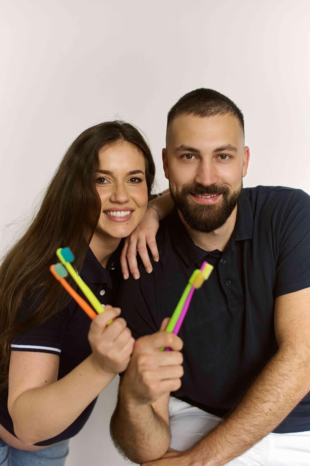 MDDr. Tereza Ager a Dan Ager v tmavých polokošilích s barevnými zubními kartáčky